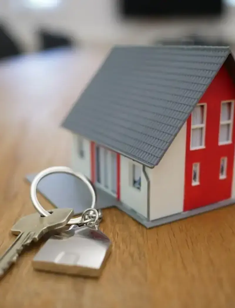 keys next to a small house figurine