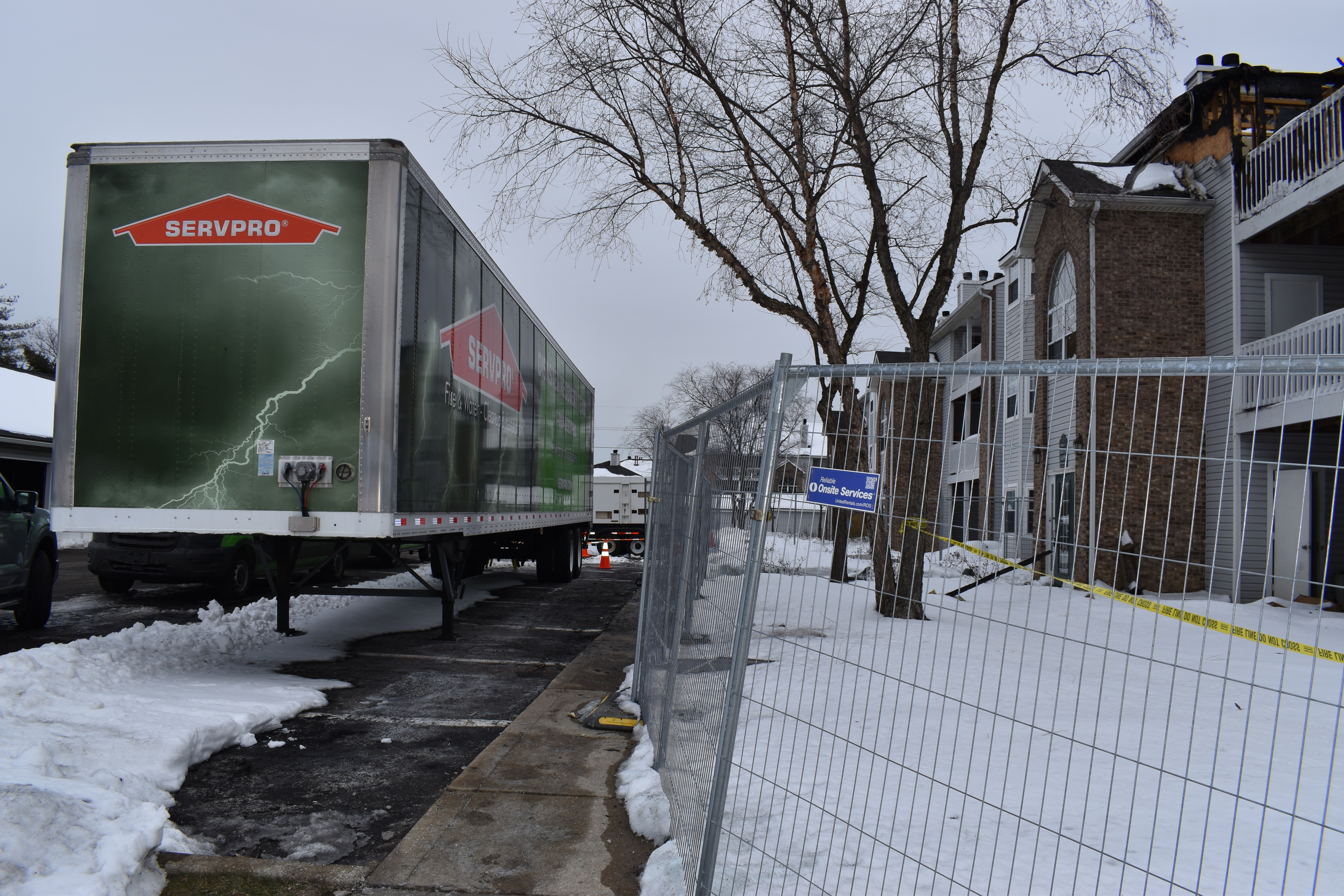 Restoration truck outside of damaged apartment building 