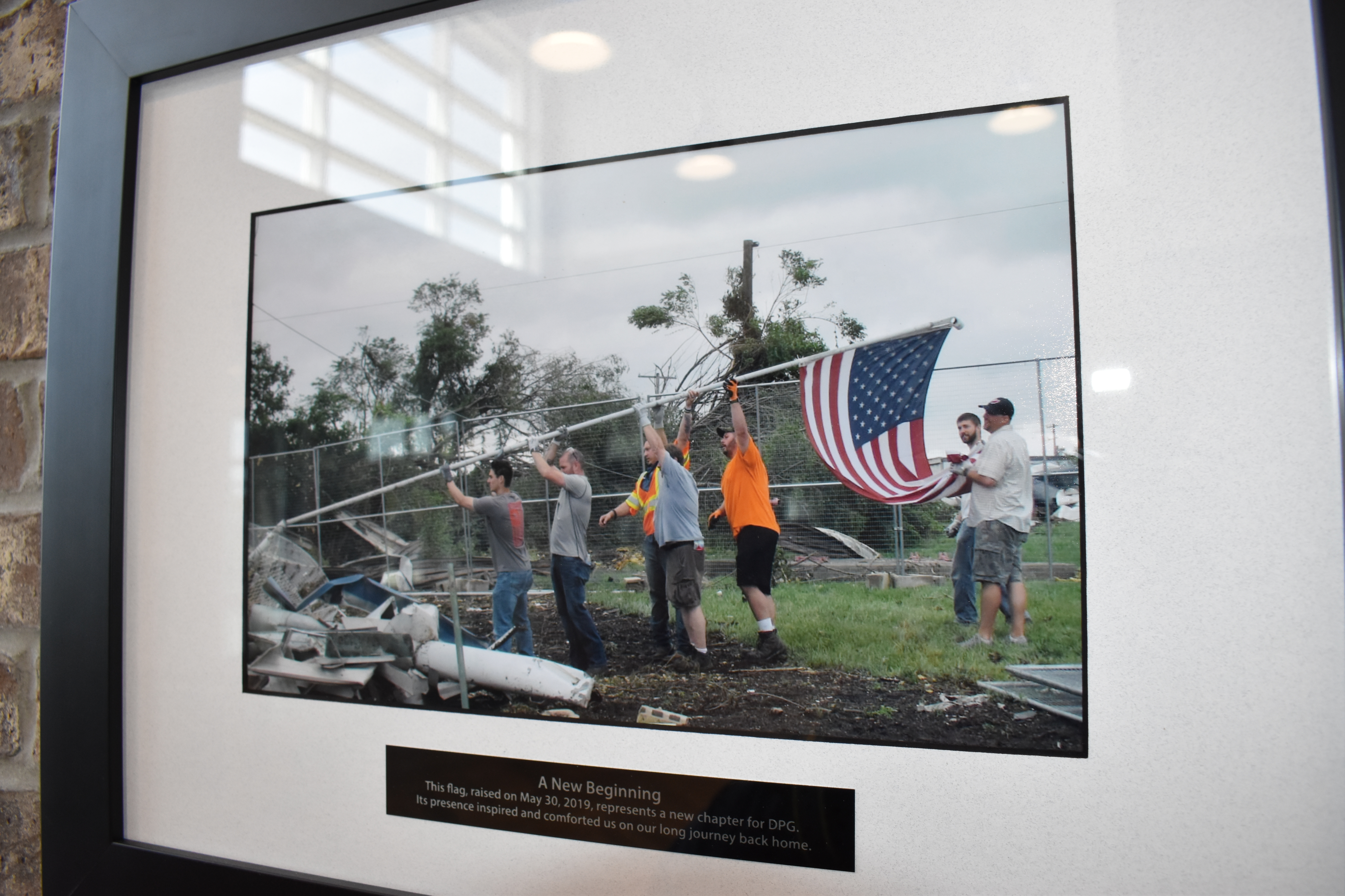 Picture of a photo in a frame on a wall of men raising an American flag 